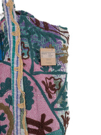 Nærbillede af Suzani vintage kantha strandtaske med lyserødt patchworkstof, blomsterbroderi og stribet skulderrem