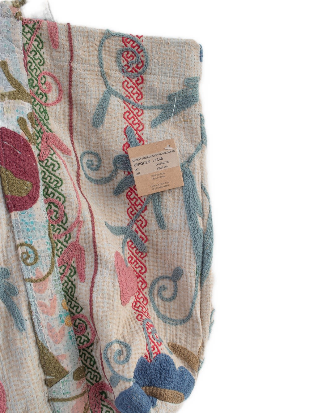 Nærbillede af vintage Suzani kantha strandtaske i cremefarvet bomuld med flerfarvet blomsterbroderi og teksturerede syninger